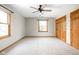 Bright bedroom with windows, carpet, ceiling fan, and wood doors to closets at 5695 N Red Oak Dr, Greenfield, IN 46140