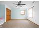 Light-filled bedroom features plush carpet, a ceiling fan, and a built-in bench near the closet at 5695 N Red Oak Dr, Greenfield, IN 46140