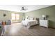 This bedroom features ample natural light, a ceiling fan, and hardwood flooring at 5695 N Red Oak Dr, Greenfield, IN 46140