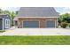Brick two-car garage, side shed, and concrete driveway create ample parking space at 5695 N Red Oak Dr, Greenfield, IN 46140