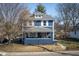 Charming two-story home features a covered front porch, gray roof, and a blue exterior at 6101 Broadway St, Indianapolis, IN 46220