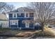 Charming blue two-story home with white framed windows and dormant landscaping at 6101 Broadway St, Indianapolis, IN 46220