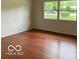 Bright living room boasting gleaming hardwood floors and a large window at 618 W Mckenzie Rd, Greenfield, IN 46140