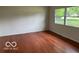 Bright living room boasting gleaming hardwood floors and a large window at 618 W Mckenzie Rd, Greenfield, IN 46140