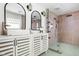 Stylishly remodeled bathroom with tiled walls, large shower, and modern vanity with dual mirrors at 6464 Whitley Ln, Indianapolis, IN 46260