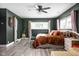 A beautifully designed bedroom featuring a ceiling fan, hardwood floors, and abundant natural light from two windows at 6464 Whitley Ln, Indianapolis, IN 46260