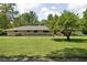 Sprawling ranch home featuring mature trees and a large lawn at 6464 Whitley Ln, Indianapolis, IN 46260