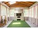 Sunroom with stone fireplace, artificial turf, skylights, and sheer curtains at 6464 Whitley Ln, Indianapolis, IN 46260