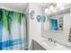 Bright bathroom with a stylish vanity, beach-themed decor, and tropical shower curtain at 6601 Valley Forge Ct, Indianapolis, IN 46237