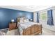 Cozy bedroom featuring a decorative blue accent wall, a wooden bed frame, and two side tables at 6601 Valley Forge Ct, Indianapolis, IN 46237
