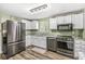 Modern kitchen featuring stainless steel appliances, light countertops, and wooden flooring at 6601 Valley Forge Ct, Indianapolis, IN 46237