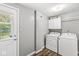 Functional laundry area with a white washer, dryer, and storage cabinet at 6601 Valley Forge Ct, Indianapolis, IN 46237