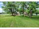 Sprawling backyard featuring mature trees, lush greenery and a fire pit at 6644 Mcfarland Rd, Indianapolis, IN 46227