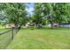 View of a home's backyard featuring mature trees and a chain link fence at 6644 Mcfarland Rd, Indianapolis, IN 46227
