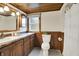 Traditional bathroom featuring wood paneled walls, a decorative window and a sink vanity at 6644 Mcfarland Rd, Indianapolis, IN 46227