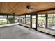 Charming sunroom featuring knotty pine ceilings, neutral walls and carpet, and an abundance of windows at 6644 Mcfarland Rd, Indianapolis, IN 46227