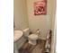 Well-lit powder room with a pedestal sink, modern toilet, and stylish decor at 6731 Keepsake Dr, Whitestown, IN 46075