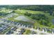 Aerial view of a new development featuring modern homes, serene ponds, green spaces, and a golf course in the backdrop at 7171 E Rising Sun S Cir, Camby, IN 46113