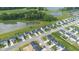 Drone view of a residential area showcasing modern homes surrounding a pond and bordering a lush green golf course at 7171 E Rising Sun S Cir, Camby, IN 46113
