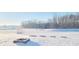 A snow covered backyard on a bright day at 7171 E Rising Sun S Cir, Camby, IN 46113