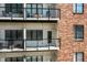 Close-up of the building's brick exterior and multi-level balconies with stylish railings at 721 E North St # 2C, Indianapolis, IN 46202