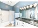 This bathroom features a dual sink vanity, shower and tub combo, and a tiled floor at 721 E North St # 2C, Indianapolis, IN 46202