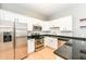 Kitchen features stainless steel appliances, white cabinets, subway tile backsplash and granite countertops at 721 E North St # 2C, Indianapolis, IN 46202