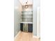 Close up of a wet bar featuring glass shelving, mosaic tile backsplash, and wine storage and beverage fridge at 721 E North St # 2C, Indianapolis, IN 46202
