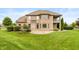 Back exterior features a well manicured lawn, manicured landscaping, and a brick home with an elevated deck at 725 Ridge Gate Dr, Brownsburg, IN 46112