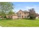 Brick two story home featuring a well-manicured lawn and mature landscaping at 725 Ridge Gate Dr, Brownsburg, IN 46112