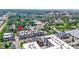 Aerial view of townhomes with a red map pin on the roof, with lush trees and buildings in the distance on a sunny day at 751 Switchyard Pl, Indianapolis, IN 46202