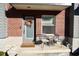 Charming front porch with a brick facade, seating, and a decorative wreath on the door at 751 Switchyard Pl, Indianapolis, IN 46202