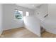 Hallway with hardwood floors, leading to a staircase with carpet, and a window overlooking trees at 751 Switchyard Pl, Indianapolis, IN 46202