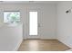 Bright hallway with hardwood floors, white walls, and a door to the outside with a window at 751 Switchyard Pl, Indianapolis, IN 46202