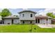 A view of backyard and home's exterior featuring stone accents and lush green lawn at 8015 Ridgegate East Dr, Indianapolis, IN 46268