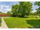 Large grassy backyard featuring mature trees and partial privacy fencing at 8015 Ridgegate East Dr, Indianapolis, IN 46268
