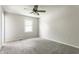 This bedroom features neutral walls, carpet floor, a ceiling fan, and a window at 8015 Ridgegate East Dr, Indianapolis, IN 46268