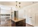 Open-concept kitchen with a center island, dark cabinets, and a view into the living space at 8015 Ridgegate East Dr, Indianapolis, IN 46268
