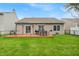 Lush backyard featuring a wooden deck with outdoor seating, a grill, and green lawn at 8315 Exton Rd, Indianapolis, IN 46239
