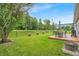 Well-maintained backyard featuring a wood deck, patio furniture, and lush greenery at 8315 Exton Rd, Indianapolis, IN 46239