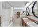 Well-lit bathroom featuring double sinks, and shower and tub with neutral tile at 8315 Exton Rd, Indianapolis, IN 46239