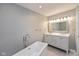 Bright bathroom featuring soaking tub, vanity, and modern fixtures at 8955 Stonegate Rd # A, Indianapolis, IN 46227