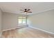 This bedroom features a ceiling fan, a window, and wood-look flooring at 8955 Stonegate Rd # A, Indianapolis, IN 46227
