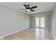 Spacious bedroom featuring wood-look flooring, ceiling fan, and patio access at 8955 Stonegate Rd # A, Indianapolis, IN 46227