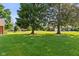 Lush green backyard with mature trees providing shade at 1010 Maple St, Greenwood, IN 46142