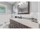 Updated bathroom featuring a granite countertop, wood vanity, and white tiled walls at 1010 Maple St, Greenwood, IN 46142