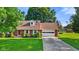Charming brick ranch home with a well-manicured lawn and an American flag at 1010 Maple St, Greenwood, IN 46142