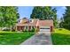 Charming brick ranch home with a well-manicured lawn and an American flag at 1010 Maple St, Greenwood, IN 46142