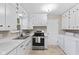 Cozy kitchen with white cabinetry, stainless steel appliances, and a laundry area at 1010 Maple St, Greenwood, IN 46142