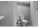 Neutral-toned bathroom features a toilet, sink, and walk-in shower with gray walls at 10312 Gladeview Dr, Indianapolis, IN 46239